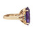 Left view of the ring showing the ring band and 14Kstamp markings inside the band in yellow gold with side view of sapphire stone with three diamonds and the claw stone setting. 