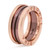 An image of a Bvlgari B.Zero1 unisex adult ring without stones, positioned centrally and captured from a side angle that emphasizes the ring's thickness and the brand's engraved logo. The ring appears to be made of rose gold and ceramic, featuring a two band design with varied shades, and the distance is such that the entire ring is in clear focus. The inner part of the ring, visible through the angle, displays additional engravings and hallmarks.The condition of the ring is new. 