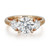 An image of a Rachel Koen women's engagement ring with lab grown diamonds, showcasing a large central round-cut diamond flanked by two smaller heart-shaped diamonds, set in a polished yellow gold band. The ring is presented in a close-up view with a direct, front-facing angle that highlights the brilliance and facets of the diamonds.
