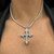 An image of a Rachel Koen brand necklace with diamonds, designed for women. The necklace features a diamond-encrusted cross pendant. It is displayed at a straight-on angle, centered on the neckline of a person wearing a black garment. The necklace and pendant rest just above the collarbone, and the image is taken from a close, frontal perspective, capturing the shine of the diamonds and the details of the pendant's design.