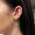An image of a woman's ear wearing a hollow hoop earring without stones from Rachel Koen. The earring is positioned on the left ear, viewed from a side angle, and is captured at a close distance, showcasing its smooth and polished metallic surface.Excellent pre-owned condition. 