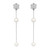 An image of Damiani earrings designed for women, featuring a close-up front view. The earrings showcase a delicate chain adorned with diamonds and pearls, with two pearls evenly spaced along the length in white gold. The diamond-studded top is shaped like a floral motif, and the overall composition is centered in the frame, highlighting the elegance and craftsmanship.