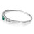 An image of a women's bracelet by Rachel Koen, featuring diamonds and emerald. The bracelet is positioned at a slight angle, showcasing its elegant curvature and intricate design in white gold. The central gemstone, an emerald, is prominently displayed, surrounded by smaller diamonds. The image captures the bracelet from a close-up perspective, highlighting the details and craftsmanship.