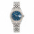 An image of a pre-owned women's Rolex Lady Datejust 26MM 18K White Gold Steel Roman Blue Dial Watch 179174 viewed from a straight-on angle. The watch features a blue dial with Roman numerals and luminous hands. The date is visible through a magnified window. The bracelet is 18k white gold with a mix of polished and brushed links. The watch is positioned centrally and up close, showcasing its details.