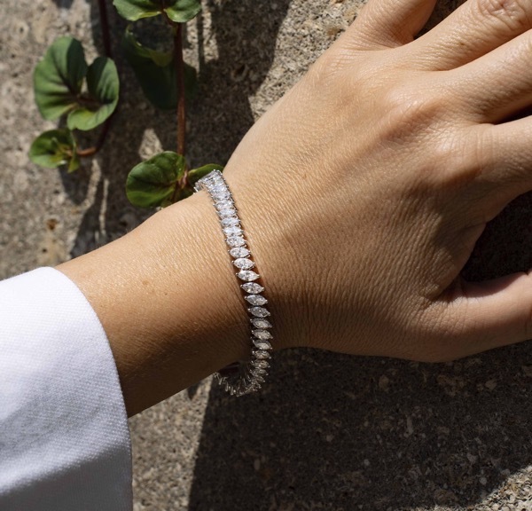 An image of a woman wearing a diamond encrusted cuff bangle on her wrist