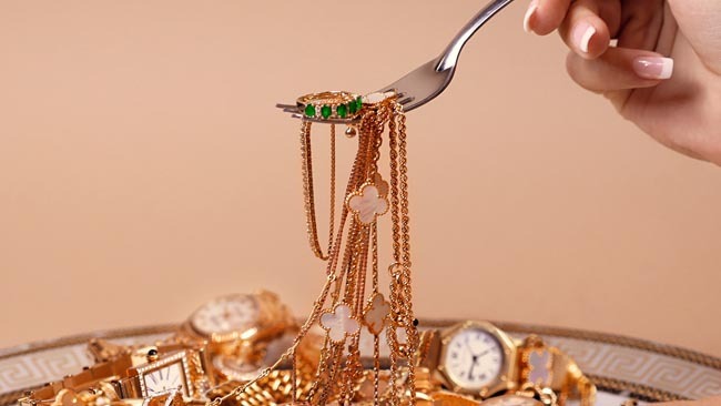 An Image of A Female's Hand Displaying Various Gold Bracelets with Diamonds. 