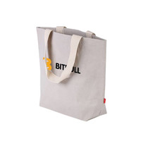 A large, grey washable kraft paper bag with cotton handles and a logo on the front.