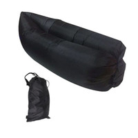 An inflatable lazy bed in black, folded and stored in a matching black carry bag.