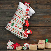 A full-colour Christmas stocking features festive designs of reindeer, trees, and ornaments, hanging against a wooden backdrop.