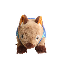 A brown and cream wombat plush toy wearing a blue floral shirt, with large ears and friendly eyes.
