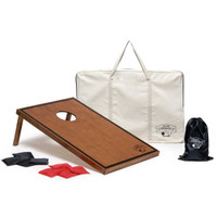 A wooden cornhole board with an oval hole, accompanied by black and red bags and a carry bag featuring a logo.