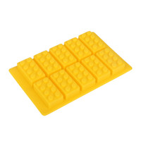A yellow silicone ice cube tray shaped like building blocks, featuring eight moulded sections with rounded bumps.