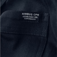 Detailled photo of a navy unisex over shirt showing a small pip label on the chest pocket