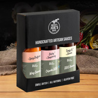 Handcrafted artisan sauces gift pack, featuring Spicy Buffalo, Stick Raspberry Chipotle BBQ, and Kansas City BBQ Sauce.