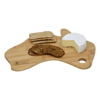 A bamboo cheese board shaped like Australia, featuring cheese and assorted crackers. It has a logo.