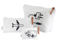 A set of three cream-coloured canvas bags with black designs, featuring an airplane, charger symbol, and key motif.