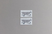 Two rectangular seed paper business cards in light grey with blue text and a circular logo, promoting sustainability.