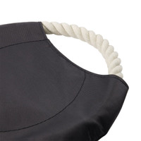 A round dog toy in black fabric with a white rope handle. The toy features a smooth, textured surface.
