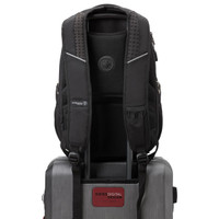 A black backpack with padded straps and a logo, resting on top of a silver suitcase.