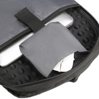 A close-up of a black backpack interior, featuring a laptop and a grey pouch with a circuit pattern.