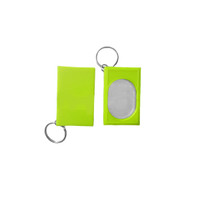 A bright green pet training clicker with a keyring attachment, featuring an oval reflective surface.
