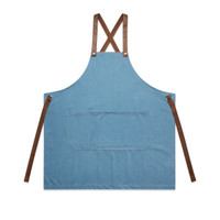 A denim apron in blue with brown leather straps and a large front pocket, featuring a logo.