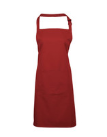 A red bib apron featuring a pocket and an adjustable neck strap. It has a simple design and includes branding.