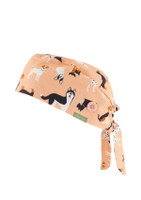 A unisex scrub cap in a light peach colour, featuring a pattern of various dogs and a button detail.