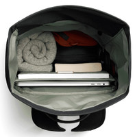 A black rolltop bag with a grey interior, containing a laptop, a book, and rolled clothing.