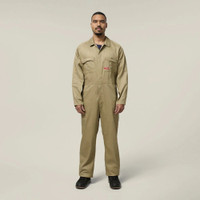 Male model wearing a khaki work jumpsuit and black work boots against a neutral background.