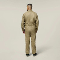 Back view of male model wearing a khaki work jumpsuit and black work boots against a neutral background.