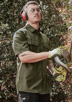 A man wearing an olive green short sleeve button-up shirt, safety glasses, and ear protection, using a power tool.