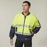 Man wearing a yellow and navy high visibility safety jacket with reflective stripes.