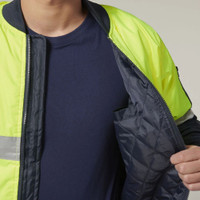 Person wearing a neon yellow reflective jacket with inner pocket detail.