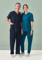 A man in navy scrub pants and top stands next to a woman in teal scrub pants and top, both smiling.