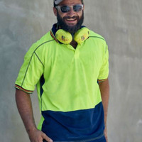 Construction worker in high-visibility clothing wearing safety gear and sunglasses.