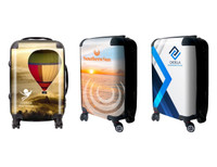 Three wheeled carry-on suitcases featuring colourful designs, including a hot air balloon, sunset, and abstract patterns.