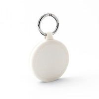 A white keychain with a circular design and a silver metal ring. The keychain features a subtle textured pattern.