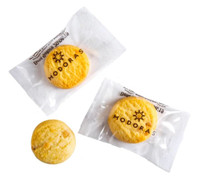 Three bite-sized biscuits in clear packaging, featuring a logo. Biscuits are golden yellow with a textured surface.