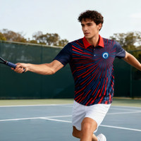 A man is wearing a red and navy blue polo shirt with a logo, holding a tennis racket on a court.