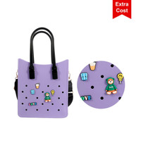 A purple tote bag with black handles, featuring playful embellishments and a logo.
