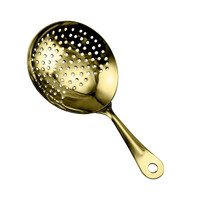 A gold cocktail strainer with a smooth handle and perforated bowl for filtering drinks.