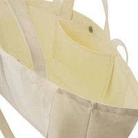A cream canvas bag with sturdy handles and an interior pocket, showcasing a smooth, spacious design.