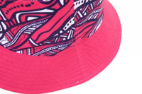 A reversible bucket hat featuring a vibrant pink and patterned design, with a textured brim and a logo.