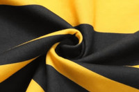 A close-up of folded fabric featuring bold black and yellow stripes, showcasing its texture and pattern.