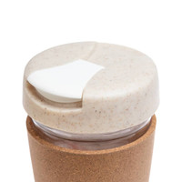 A reusable coffee cup with a cork band and a light-colored lid featuring a sliding opening.