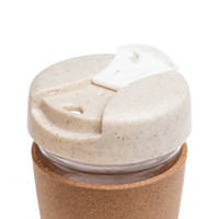 A reusable coffee cup featuring a cork band, with a lid made from a sustainable material that has a speckled design.