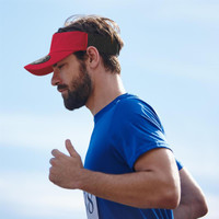 A red visor with a logo, worn by a man in a blue shirt, set against a clear sky.