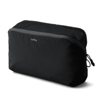 A black packing cube with a zippered mesh top, featuring branding on the front.