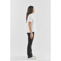 A woman stands in profile wearing a white polo shirt and black pants, with a simple design and no visible branding.